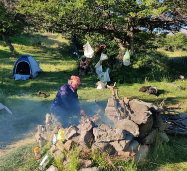 People are gathered around a campfire at a campsite.