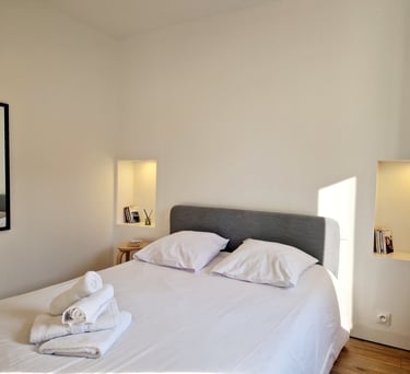 a bed with a white bed and a mirror