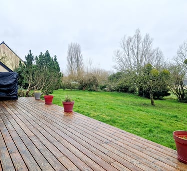 a deck with potted plants and a grill grill