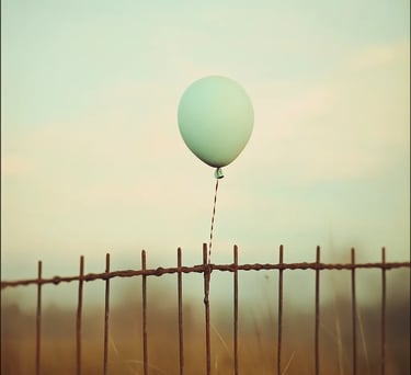 Ballon vert pâle flottant au-dessus d’une vieille clôture rouillée, ambiance vintage et mélancolique.
