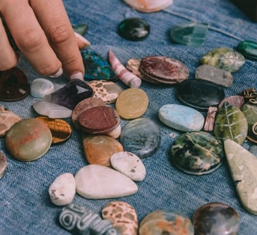 Una persona seleccionando diversas piedras pulidas y cristales energéticos