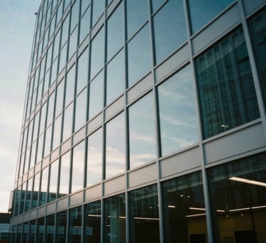 An architectural wide shot of a glass-walled conference room in a North American / US headquarters, reflecting a muted light blue sky.
