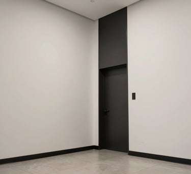 A low-angle shot of a minimalist North American / US office lobby with off-white walls and sleek charcoal black accents.