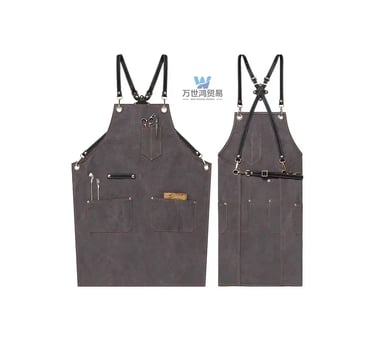 Professional grey canvas barber apron with cross-back leather straps and multiple tool pockets.