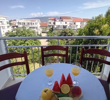 a table with a plate of fruit and glasses of wine