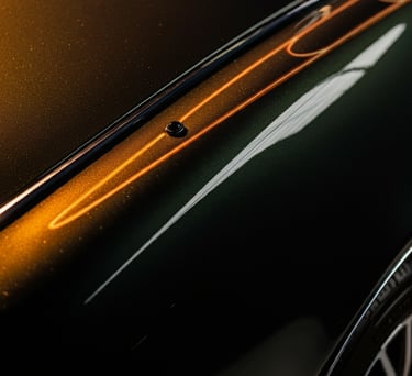 imagem aproximada de parte da lataria de um automóvel de cor escura, demonstrando seu brilho.