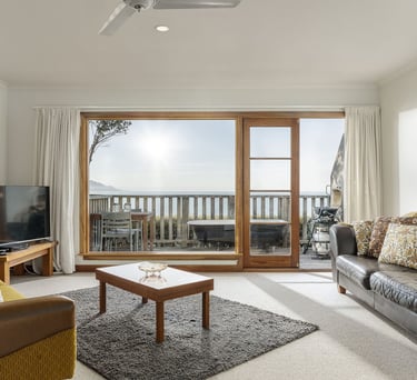 The Studio lounge opening to private deck with ocean views