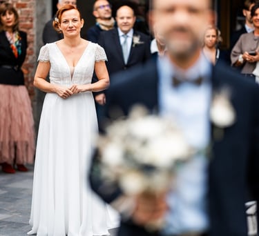 Une femme en robe de mariée blanche derrière son mari