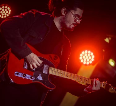 Dimitri jouant avec une telecaster fender rouge éclairé par un spot rouge au concert de rush on mars