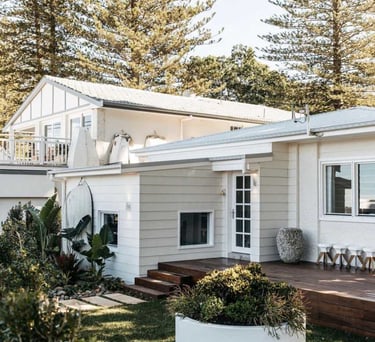 a white house with a large white planter and a large potted planter