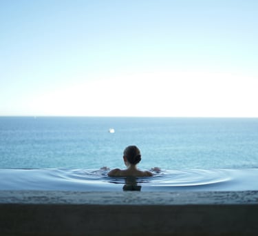 eine Person in einem Pool mit Blick auf das Meer