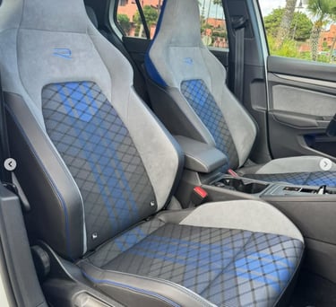 Volkswagen Golf R interior featuring gray alcantara bucket seats with blue tartan plaid patterns.