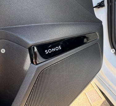 A Sonos premium car audio speaker system integrated into a black vehicle door panel.