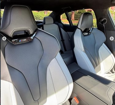 Luxury BMW M5 interior featuring two-tone grey leather sport bucket seats with M series branding.