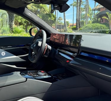 Luxury modern car interior with digital dashboard display and carbon fiber trim.