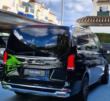 Luxury black Mercedes-Benz Maybach passenger van for rent parked in a residential driveway.
