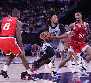 Stephon Castle of the Spurs controls the ball against Kris Dunn and John Collins of the Clippers