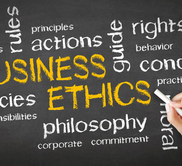 Hand writing business ethics and corporate conduct keywords on a black chalkboard.