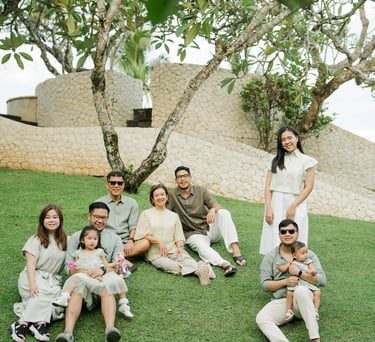 Large family enjoying time together in a tropical garden during a Bali family photography session.