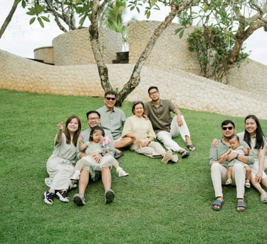 Extended family gathered together on a resort garden lawn during a multigenerational family photography session in Bali.
