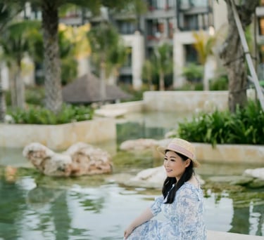 Woman standing beside the lagoon during a portrait session at The Apurva Kempinski Bali