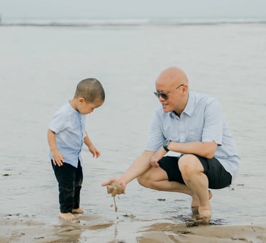 Father and son enjoying quiet moments together on the beach at Nusa Dua Bali