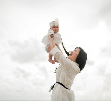 Mother lifting baby at Seminyak Beach Bali during soft and emotional family photography moment.