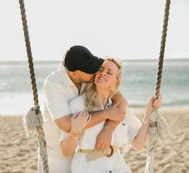Mother and daughter sharing a loving embrace on a beach swing during a family photography session at Ayodya Resort Bali