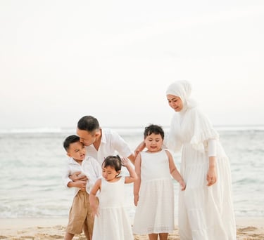 Warm and intimate family portrait of Ilham family at Melasti Beach Bali during golden hour