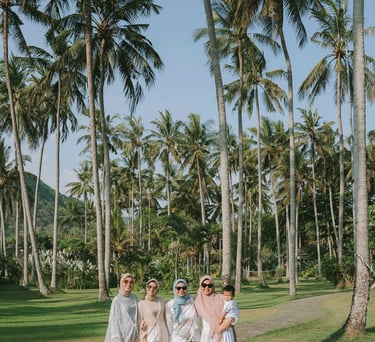 Group of women walking through palm garden during photoshoot at Candi Beach Resort Karangasem Bali