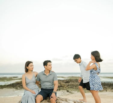 Family enjoying a candid beach moment during a luxury family photography session at The Ritz-Carlton Bali.
