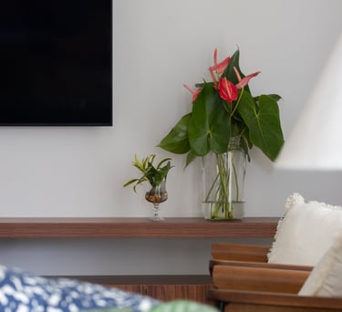 sala de tv com vaso de flores vermelhas