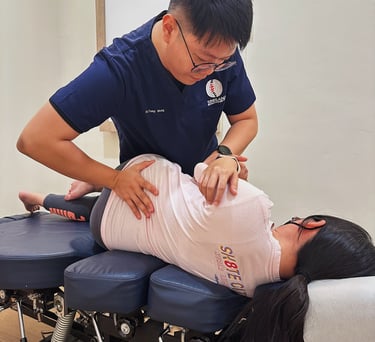 Chiropractor aligning patient’s spine using side posture technique at Sinisana Chiropractic.