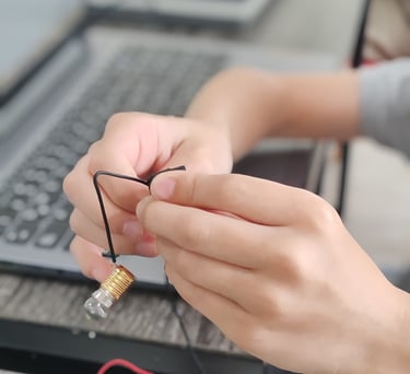 Alumno armando un circuito y aprendiendo electrónica práctica.