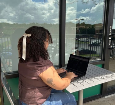 a woman sitting at a table with a laptop