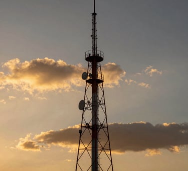 A scenic view of a radio tower against a dramatic Mexican sunset with golden and dark tones, symbolizing reach and power.