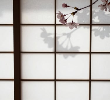 A high-detail close-up of a white paper shoji screen with the soft, elegant shadow of a cherry blossom branch cast upon it from the sun. Minimalist, zen aesthetic with soft pink and gray tones.