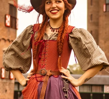 Een vrolijke piratenprinses met een hoed, rode vlechten en een korset poseert op een evenement.