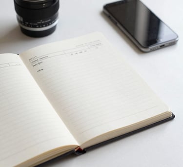 A bright, clean photo of an open notebook and a smartphone on a desk, representing planning and mental wellness tracking, North American / US style.