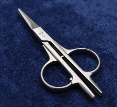 A detailed shot of neurosurgical forceps resting on a dark blue velvet surface. The lighting catches the polished steel edges, showcasing the fine tips and high-quality finish of the Pakistani-made instrument.