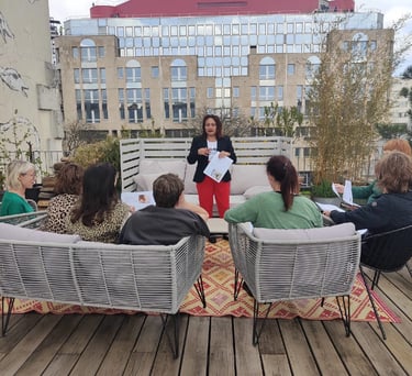Groupe d’élèves assis sur une terrasse, suivant une formation dirigée par une formatrice.