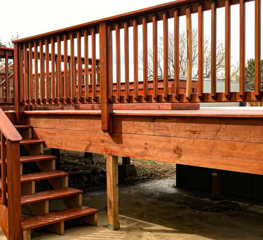 Completed residential wooden deck with stairs leading to a yard, built by Brewer Construction in Golden.