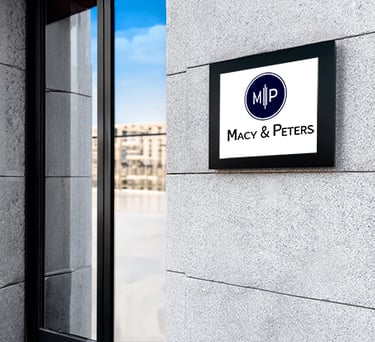 Macy & Peters professional law firm office signage on a modern stone building facade.