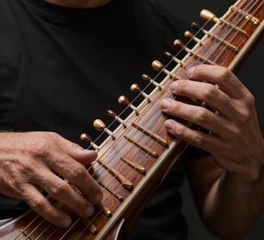 A close-up shot of hands playing a polished wooden Sitar, focusing on the intricate strings and craftsmanship, set against a charcoal black studio background with soft gold lighting.