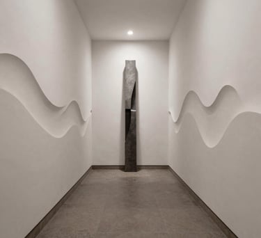 Modern minimalist black metal staircase with a thin metal handrail against a white wall.