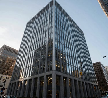 A wide-angle photograph of a sleek, modern corporate office building in a major North American city, reflecting light and professional stability.