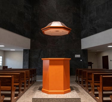 Wide shot of the ADMVA church interior in Rio de Janeiro, with modern dark architecture and bright orange highlights on the pulpit.