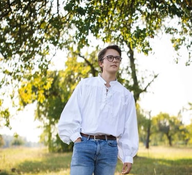 Man in blue jeans wearing an eighteenth century style mens shirt.