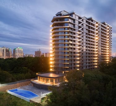 fotografia architektoniczna wielemieszzkzniowego gmachu po zachodzie słońca 