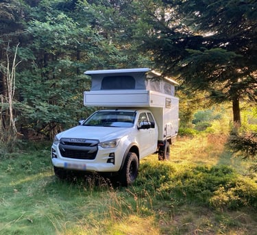 una pick-up camper 4x4 con techo elevable en el bosque